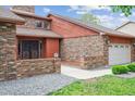 Inviting home with brick accents, complemented by manicured greenery and a spacious two car garage at 11254 E Colorado Dr, Aurora, CO 80012