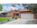 Beautiful brick home showcasing mature trees and a two-car garage in a serene neighborhood at 11254 E Colorado Dr, Aurora, CO 80012