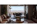 A cozy living room featuring hardwood floors, a ceiling fan, and glass doors leading to the outdoor deck with mountain views at 10640 Winding Pine Pt, Highlands Ranch, CO 80126