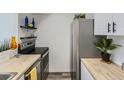 Modern kitchen showcasing stainless steel appliances and light wood butcher block countertops at 12172 E Kepner Pl, Aurora, CO 80012