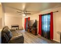 Bright living room with sleek floors, ceiling fan, and large window with decorative curtains at 10050 Holland Ct, Broomfield, CO 80021