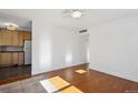 Spacious living room featuring hardwood floors and kitchen peek at 3044 Eudora St, Denver, CO 80207