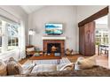 Inviting living room featuring a brick fireplace, hardwood floors, vaulted ceiling, and abundant natural light at 6960 S Knolls Way, Centennial, CO 80122