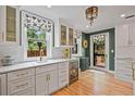 Bright kitchen featuring white cabinets, countertops, and a beverage refrigerator at 1040 N Humboldt St, Denver, CO 80218