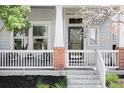 Close-up of a front porch with brick accents, white railing and seating at 5450 Uinta St, Denver, CO 80238