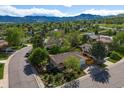 Stunning aerial view of a charming home nestled in a lush, green neighborhood with mountain views at 12420 W Atlantic Ave, Lakewood, CO 80228