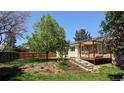 A large, well-maintained backyard with a wooden deck and a manicured lawn at 12420 W Atlantic Ave, Lakewood, CO 80228