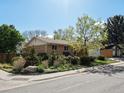 Well-maintained home featuring a manicured lawn and mature trees in a serene neighborhood at 12420 W Atlantic Ave, Lakewood, CO 80228