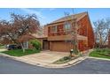Charming two-story home featuring a two-car garage, unique wood shingle siding and driveway at 10102 W Ida Ave # 214, Littleton, CO 80127