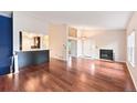 Open-concept living room with hardwood floors flowing into kitchen area at 1829 S Union Blvd, Lakewood, CO 80228
