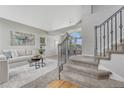 Bright living room featuring a neutral color palette, plush seating, and staircase with ornate iron railings at 901 Sage Sparrow Cir, Highlands Ranch, CO 80129