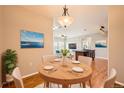 Cozy dining area featuring hardwood floors, a round wooden table set for four, and an elegant light fixture at 2705 S Danube Way # 306, Aurora, CO 80013