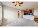 Spacious living area connecting to the kitchen, featuring a ceiling fan and ample natural light at 2705 S Danube Way # 306, Aurora, CO 80013