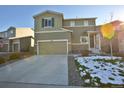 Two-story home with attached garage, a concrete driveway, and landscaping with melting snow at 1908 Homestead Dr, Fort Lupton, CO 80621
