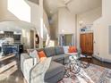 Bright living room boasts soaring ceilings, hardwood floors, and elegant staircase with comfortable, stylish furnishings at 4825 6Th St, Boulder, CO 80304