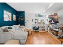 Spacious living area with hardwood floors, a plush gray sectional, and tasteful decorations at 1215 N Perry St, Denver, CO 80204