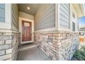 A welcoming covered front porch features stone accents, providing shelter and curb appeal at 17028 Osage St, Broomfield, CO 80023