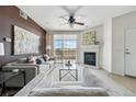 Bright living room with a fireplace, ceiling fan, and view of the balcony and landscape at 9481 E Mansfield Ave # 203, Aurora, CO 80014