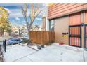 Townhouse front entrance with walkway, wooden fence, and small yard at 6462 E Bates Ave, Denver, CO 80222