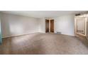 Spacious living room featuring neutral walls, plush carpeting, and a versatile layout at 8870 W Jewell Ave # 11, Lakewood, CO 80232