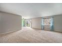 Open-concept living area with a sliding door to a balcony and view, ceiling fan, and neutral walls at 8870 W Jewell Ave # 11, Lakewood, CO 80232