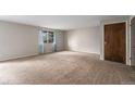 Bright living room with carpet, large window with blue curtains, and neutral wall color at 8870 W Jewell Ave # 11, Lakewood, CO 80232