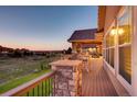 Spacious covered deck, offering stunning views and outdoor dining with stone pillars at 6963 S Espana Way, Centennial, CO 80016