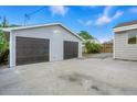 Large detached two-car garage with a concrete driveway and adjacent yard at 5541 E 65Th Ave, Commerce City, CO 80022