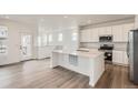 Open concept kitchen with stainless steel appliances, a center island, and sleek white cabinetry at 2090 S Haleyville Way, Aurora, CO 80018