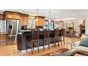 Modern kitchen featuring wooden cabinets, stainless steel appliances, a breakfast bar, and hardwood floors at 28454 Meadow Dr, Evergreen, CO 80439