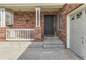 Close-up of the inviting front porch with brick accents, decorative railings, and secure front door at 3242 S Jebel Way, Aurora, CO 80013