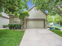 Attached garage with stone accents and well manicured yard of the home at 4501 S Tabor Ct, Morrison, CO 80465