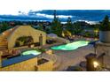 Gorgeous pool area with stone accents, water slide, in-ground hot tub, and comfortable seating arrangements at 15355 Zuni St, Broomfield, CO 80023