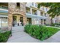 Exterior view of the condo featuring stone accents, a well-manicured lawn, and a welcoming entrance at 474 Black Feather Loop # 419, Castle Rock, CO 80104