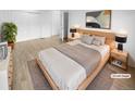 Virtually staged main bedroom with wood floors and double doors at 2685 S Dayton Way # 326, Denver, CO 80231