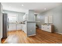 Bright, open kitchen featuring white cabinets, modern appliances, and hardwood floors at 9818 E Carolina Pl, Aurora, CO 80247