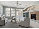 Inviting living room featuring a fireplace, large windows, and neutral-toned furniture at 9818 E Carolina Pl, Aurora, CO 80247