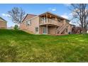 Expansive backyard with lush green lawn and a two-tiered deck with wooden stairs at 4927 Greenwich Way, Highlands Ranch, CO 80130
