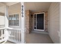 Inviting covered front porch with white columns and railings, leading to the front door of the house at 9866 Spring Hill Ln, Highlands Ranch, CO 80129