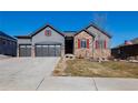 Charming two-story home featuring a three-car garage, stone accents, and manicured lawn in a residential neighborhood at 3790 Mighty Oaks St, Castle Rock, CO 80104