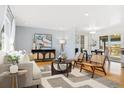 Bright living room featuring hardwood floors, modern decor, and an open layout with a dining area at 10699 W 9Th Pl, Lakewood, CO 80215