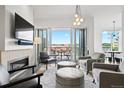 Bright living room with fireplace, comfortable seating, and balcony access at 155 Steele St # 414, Denver, CO 80206