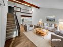 Virtually staged living room with hardwood floors, a loft, and kitchen views at 2685 S Dayton Way # 74, Denver, CO 80231