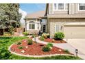 Charming two-story home with stone accents and manicured lawn with beautiful flower bed walkway at 1210 Snowberry Ln, Broomfield, CO 80020
