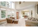 Bright living room with high ceilings, large windows, and comfortable seating arrangement at 1210 Snowberry Ln, Broomfield, CO 80020