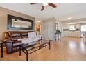 Spacious living room featuring wood floors, a ceiling fan, and seamless access to the kitchen at 9901 E Evans Ave # 9A, Aurora, CO 80247