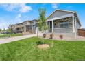 Attractive home featuring a well-maintained lawn, a small front porch, and stone detailing at 4530 Cattle Cross Trl, Castle Rock, CO 80104