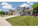 Inviting two-story home featuring a well-manicured lawn and a three-car garage at 13439 Antlers St, Broomfield, CO 80020