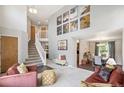 Open-concept living room with soaring ceilings, neutral paint, and easy access to dining room at 13439 Antlers St, Broomfield, CO 80020