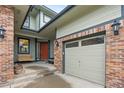 Inviting front porch featuring a porch swing, brickwork, and an adjacent two-car garage at 13250 Wild Basin Way, Broomfield, CO 80020